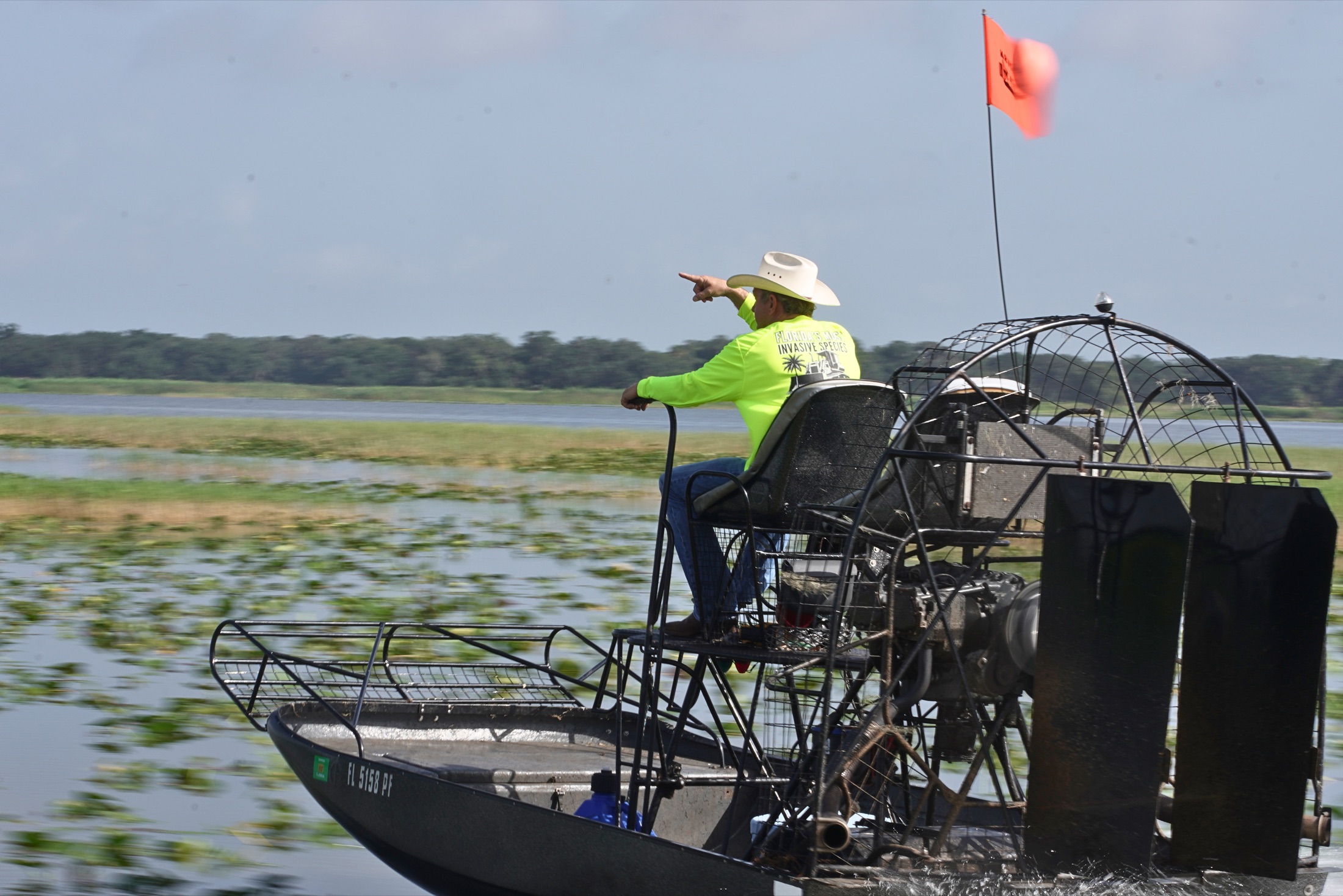Bobby Williams pointing across a Florida waterway from an airboat.